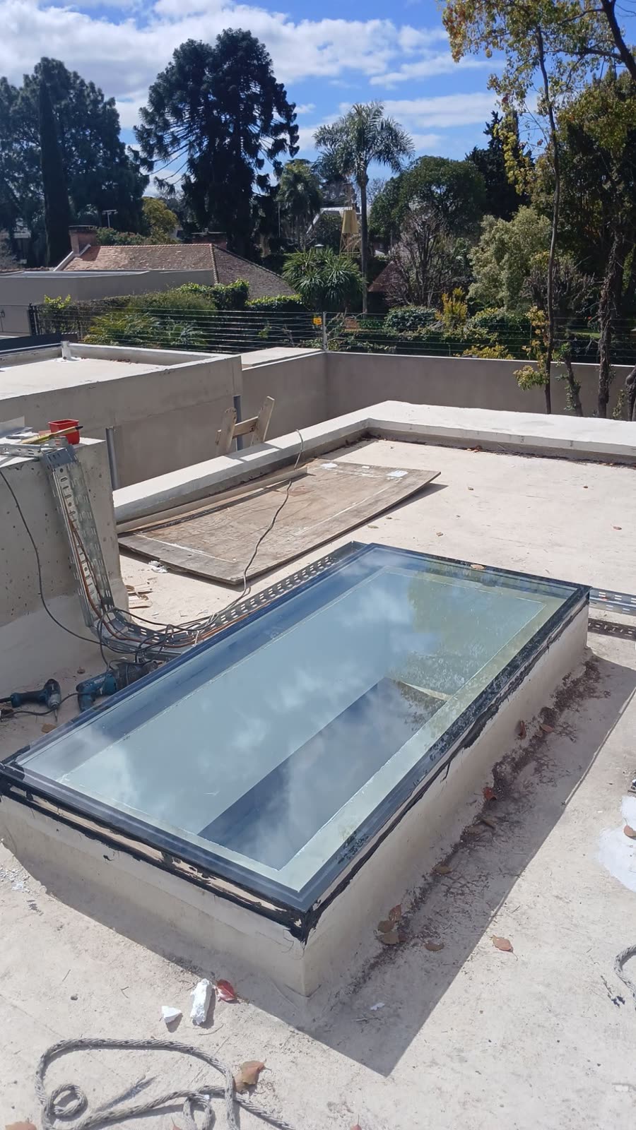 Claraboya de vidrio sobre una terraza, con árboles de fondo