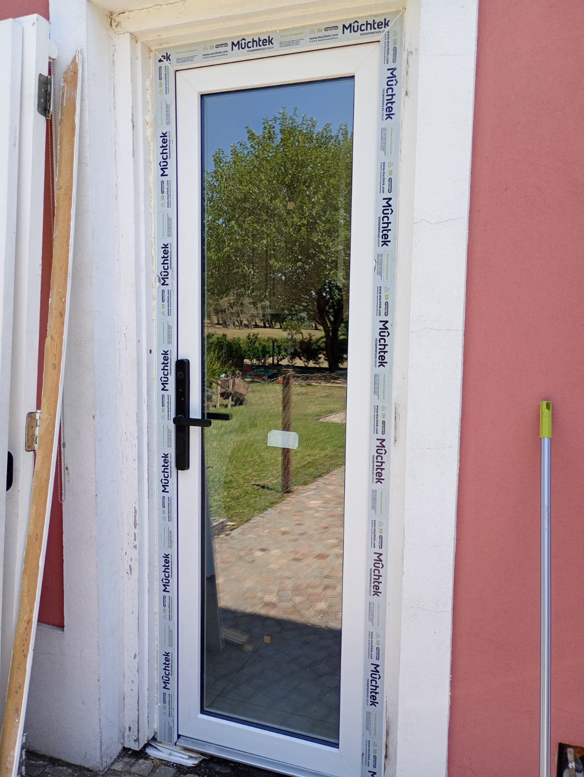 Puerta de PVC blanca recién colocada, con el film protector Rehau