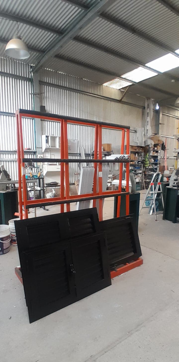 Taller con marcos de aluminio y postigos negros en fabricación